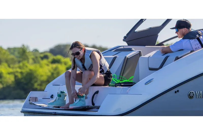 Slide: The Image of 2026 Yamaha Boats AR220 with people preparing for water activities on a sunny day. - 2