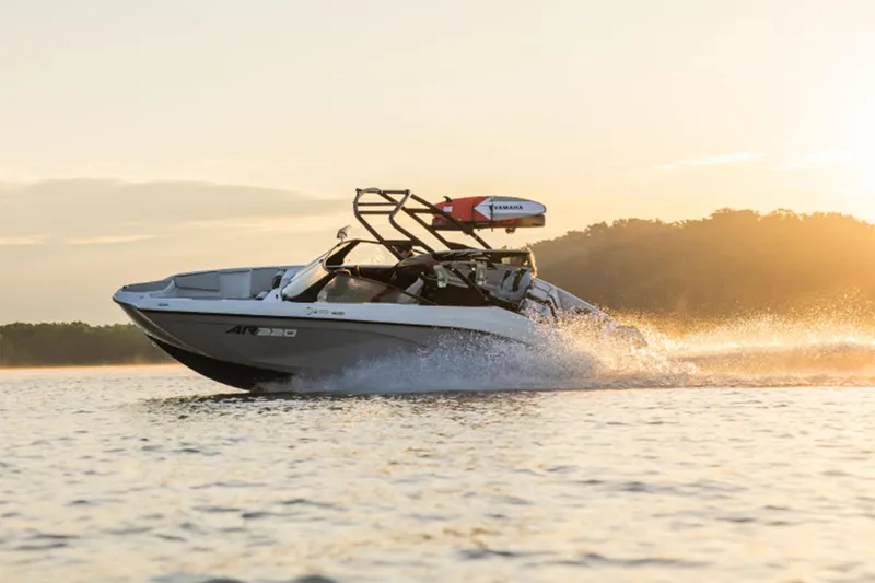 Slide: The Image of 2026 Yamaha Boats AR220 cruising on a lake at sunset. - 4