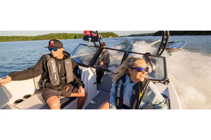 Slide: The Image of 2026 Yamaha Boats AR220 cruising on a lake with passengers enjoying the ride. - 6