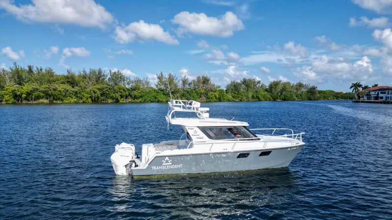 The Image of 2023 ArrowCat Flybridge Dual Helm boat on a serene lake under a blue sky. - 0