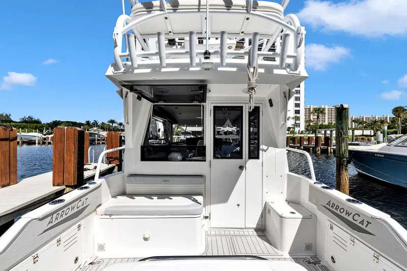 Slide: The Image of 2023 ArrowCat Flybridge Dual Helm boat docked at marina, showcasing rear deck and seating. - 22