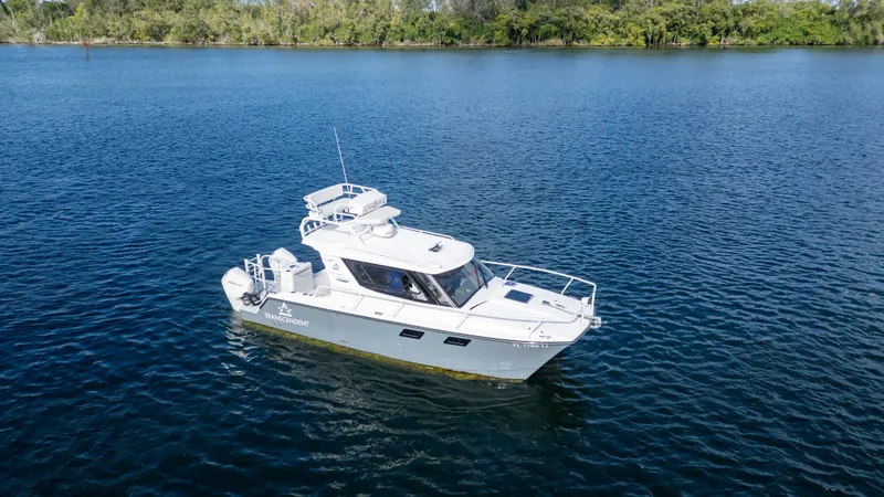 Slide: The Image of 2023 ArrowCat Flybridge Dual Helm boat on calm blue water. - 3