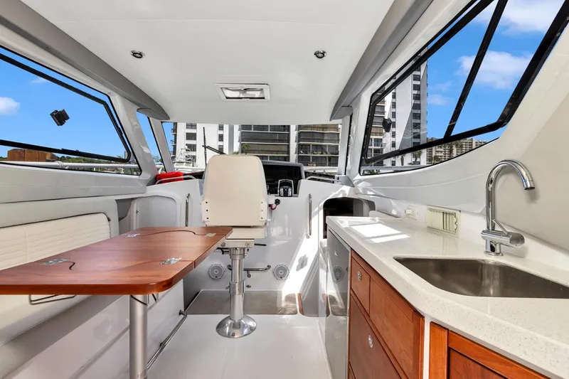 Slide: The Image of Interior of 2023 ArrowCat Flybridge Dual Helm with table, chair, and kitchenette. - 38