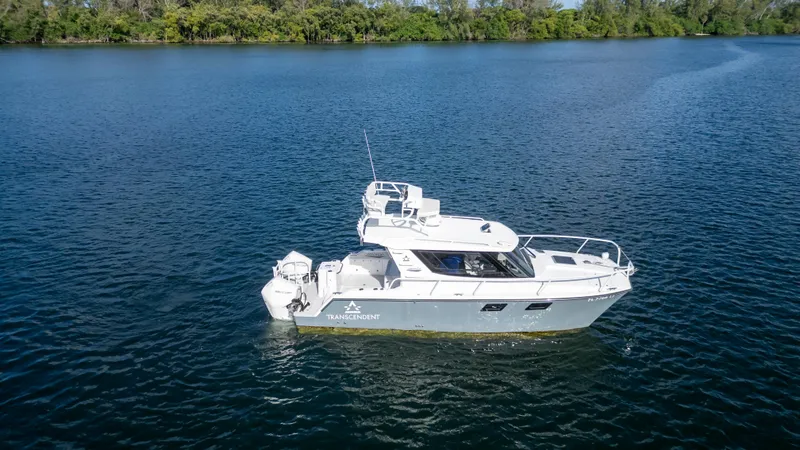 Slide: The Image of 2023 ArrowCat Flybridge Dual Helm boat on a serene lake. - 4