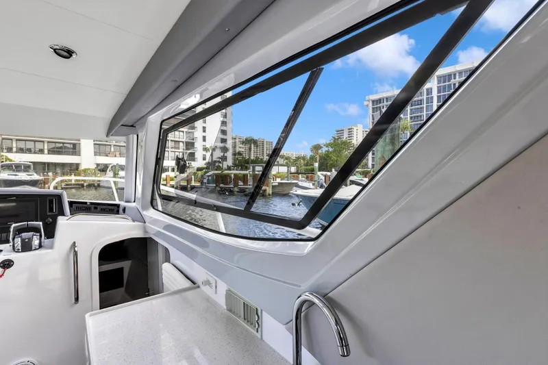 Slide: The Image of 2023 ArrowCat Flybridge Dual Helm interior with marina view through large windows. - 40