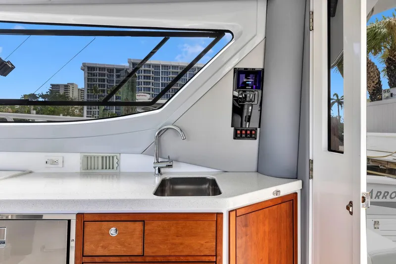 Slide: The Image of Modern kitchen area on 2023 ArrowCat Flybridge Dual Helm yacht with sleek design and city view. - 43