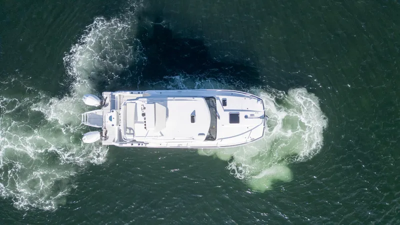 Slide: The Image of Aerial view of 2023 ArrowCat Flybridge Dual Helm boat navigating water. - 6