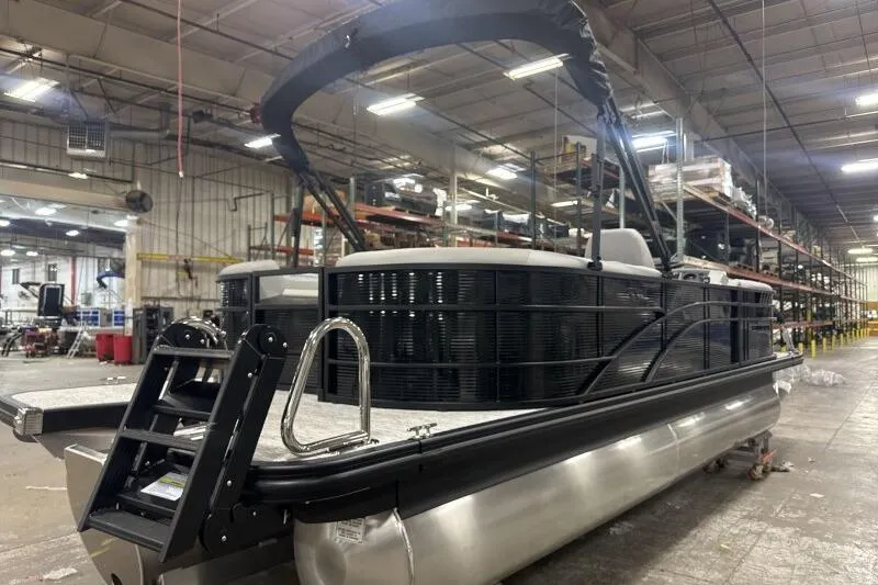 Slide: The Image of 2026 Bennington 22SXSR pontoon boat in a warehouse setting. - 16