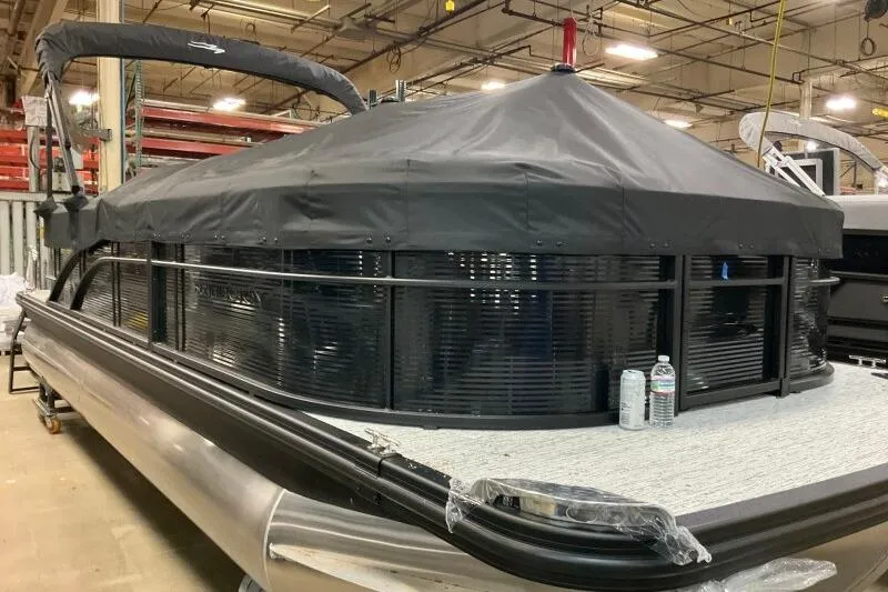 Slide: The Image of 2026 Bennington 22SXSR pontoon boat with black cover in a warehouse setting. - 3