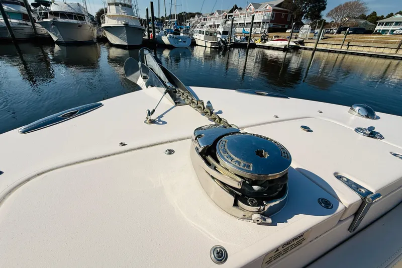 Slide: The Image of 2014 Grady-White Freedom 275 boat interior with cushioned seating at marina. - 12