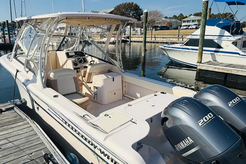 Slide: The Image of 2014 Grady-White Freedom 275 boat docked with Yamaha engines, sunny marina background. - 2