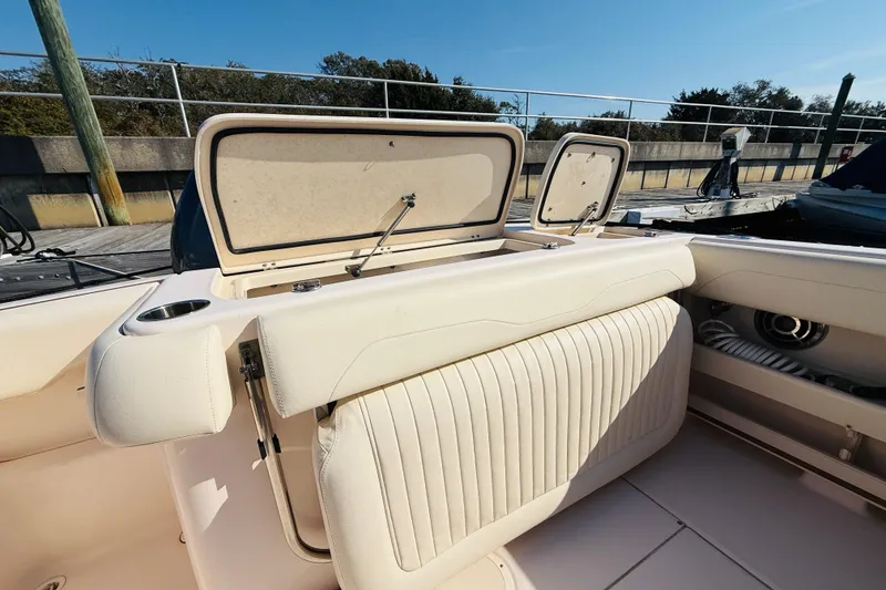 Slide: The Image of 2014 Grady-White Freedom 275 boat interior with seating and dual engines at dock. - 6