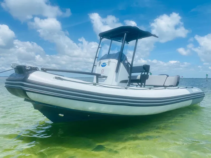 Slide: The Image of 2024 Zodiac Open 5.5 boat on clear water under blue sky with clouds. - 11
