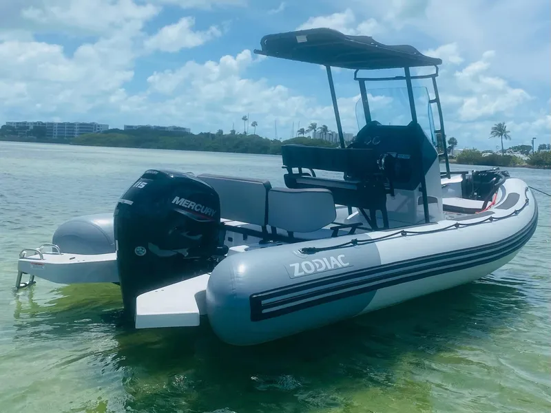 Slide: The Image of 2024 Zodiac Open 5.5 inflatable boat with Mercury outboard motor on clear water. - 8