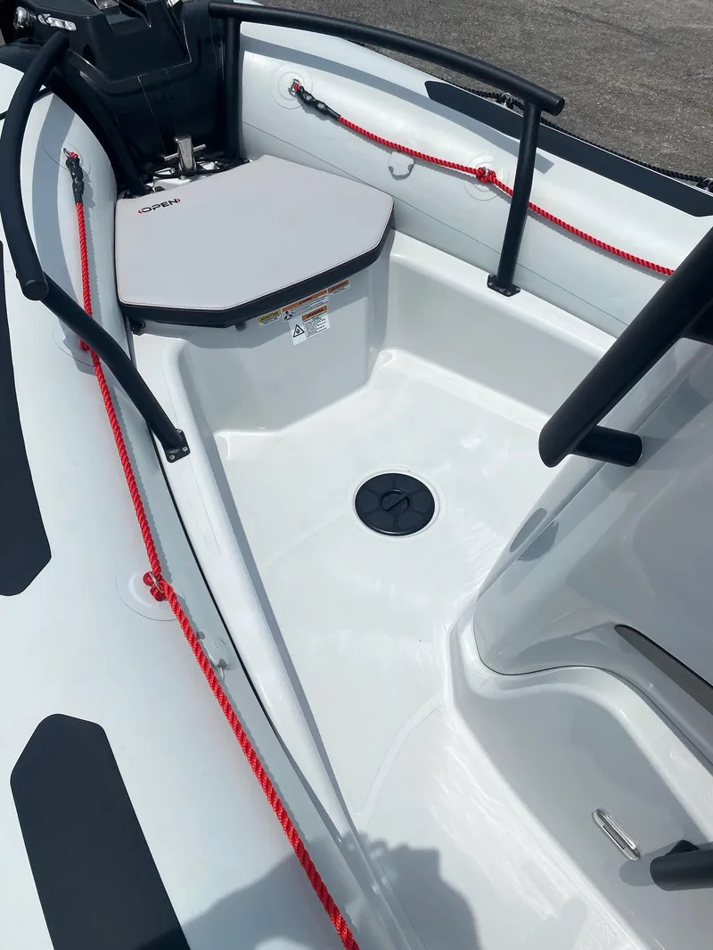 Slide: The Image of 2024 Zodiac Open 5.5 boat interior with red safety lines and seating area. - 9