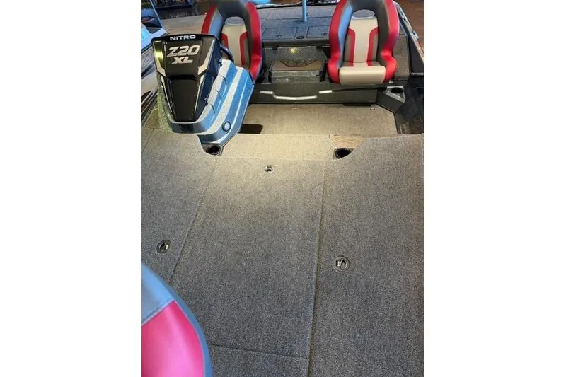 Slide: The Image of 2026 Nitro Z20 XL Pro boat interior with red seats and carpeted deck. - 9