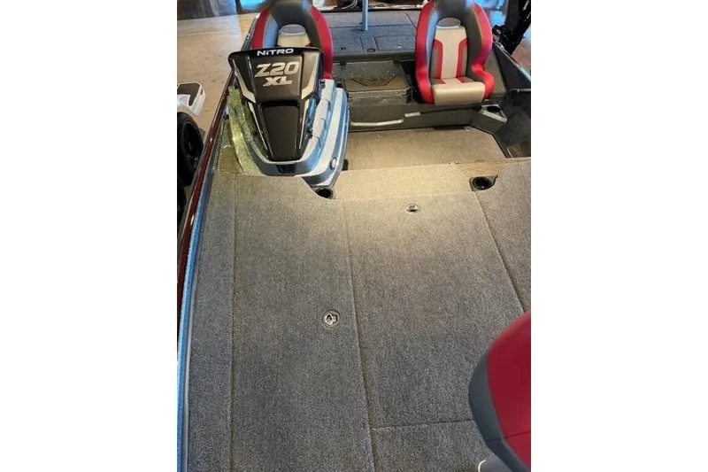 Slide: The Image of 2026 Nitro Z20 XL Pro boat interior with gray carpet and red-accented seats. - 8