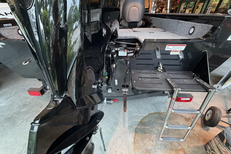 Slide: The Image of 2026 Tracker Targa V-18 Combo boat with motor and foldable ladder in a showroom. - 7