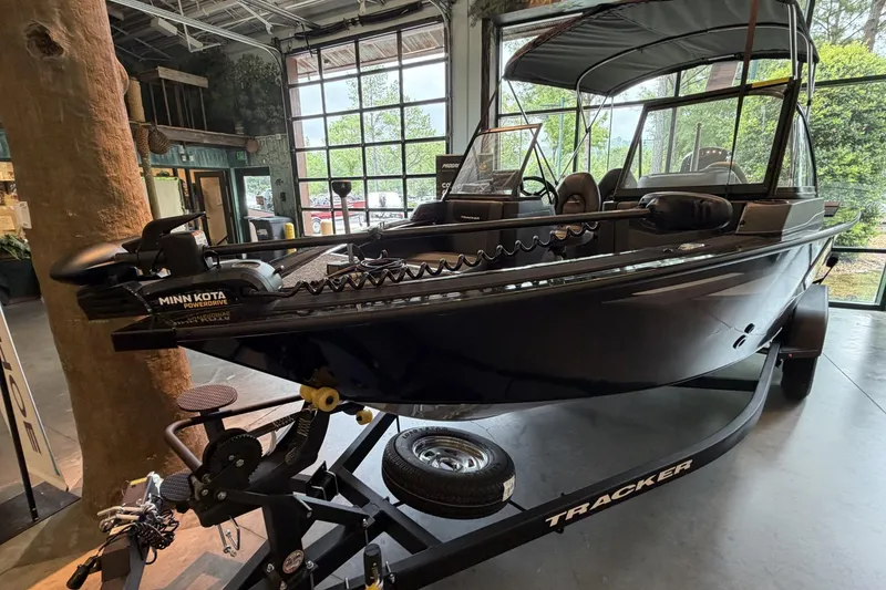Slide: The Image of 2026 Tracker Targa V-18 Combo boat on display indoors, featuring Minn Kota PowerDrive. - 2