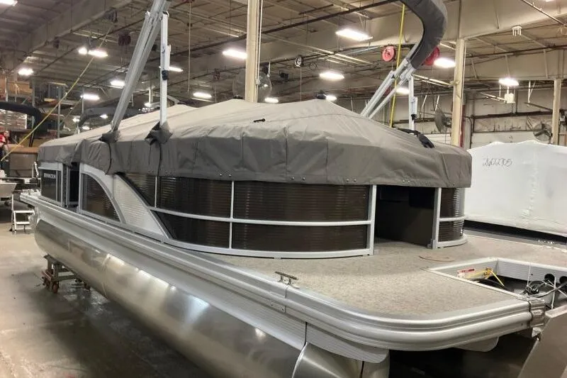 Slide: The Image of 2026 Bennington 22SXSR pontoon boat with cover in a warehouse setting. - 14