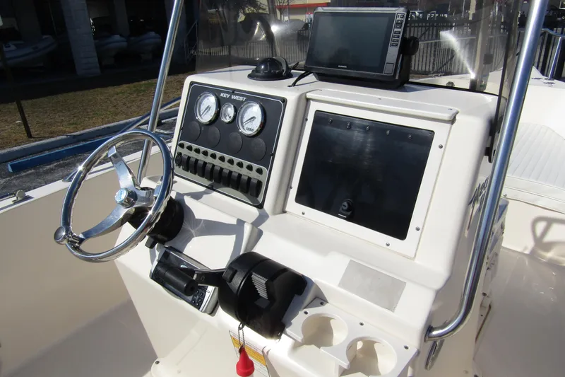 Slide: The Image of Center console of a 2004 Key West 2020 boat with steering wheel and gauges. - 21