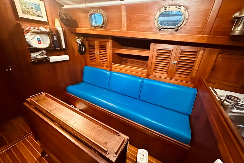 Slide: The Image of Cozy 1978 Shannon 38 yacht interior with blue seating and wooden cabinetry. - 10