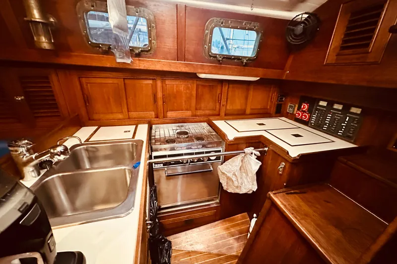 Slide: The Image of 1978 Shannon 38 yacht galley with wood cabinetry, dual sink, and stove. - 11