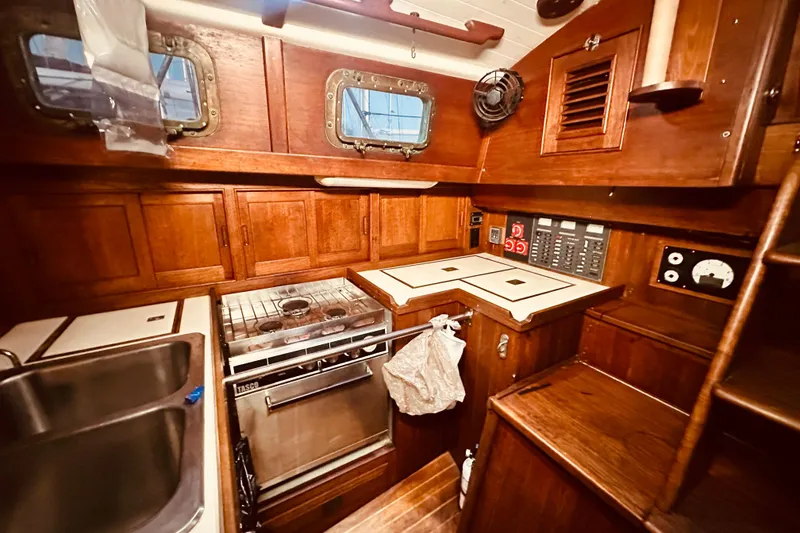 Slide: The Image of 1978 Shannon 38 yacht interior with wooden cabinetry, stove, and sink. - 8