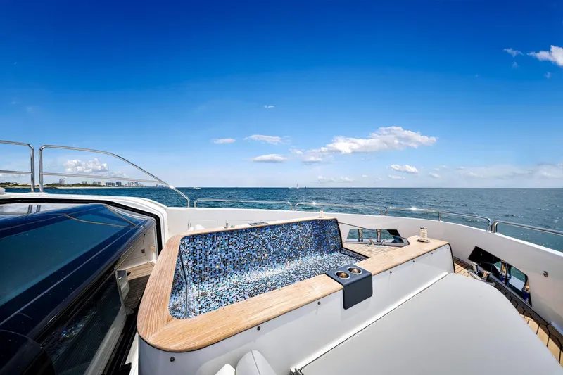 Slide: The Image of Luxurious Sirena 88 yacht deck with jacuzzi, ocean view, and clear blue sky, 2021 model. - 35