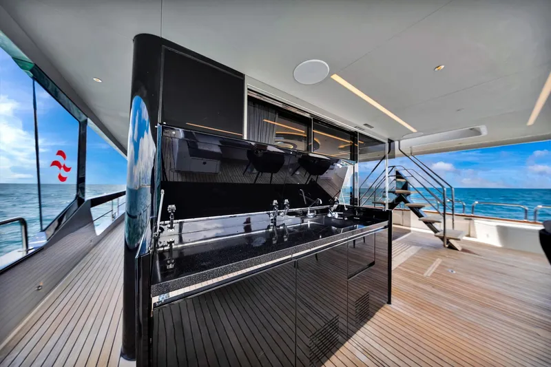 Slide: The Image of Luxurious Sirena 88 yacht deck with sleek outdoor kitchen, ocean view, and modern design. - 47