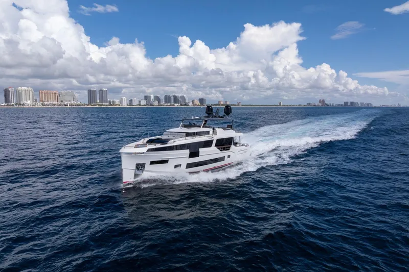 Slide: The Image of Luxurious 2021 Sirena 88 yacht cruising on open sea with city skyline backdrop. - 7