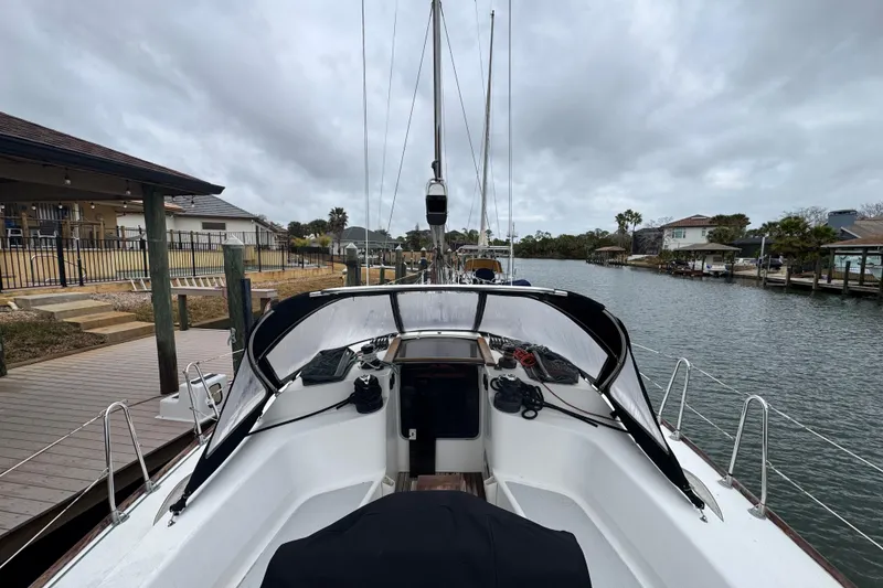 Slide: The Image of 2004 Alliaura FEELING 44 DI sailboat docked by a waterfront home under cloudy skies. - 13