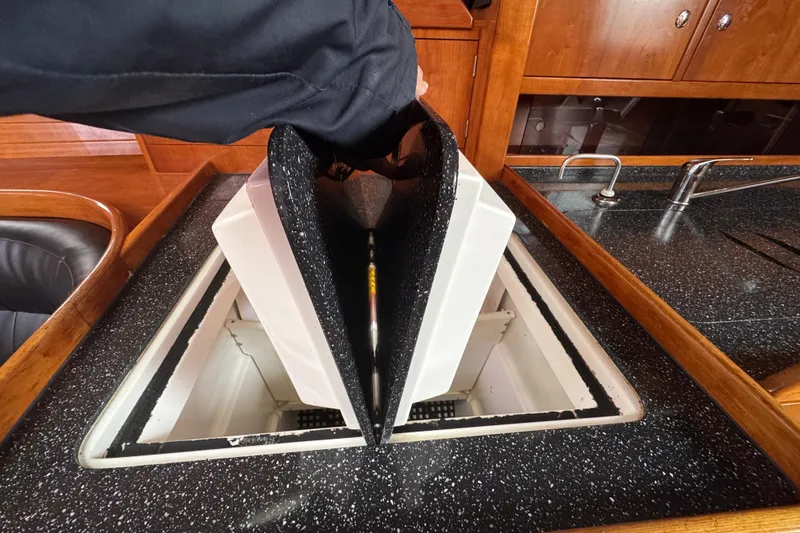 Slide: The Image of Opening hatch in 2004 Alliaura FEELING 44 DI yacht kitchen, revealing storage compartment. - 47