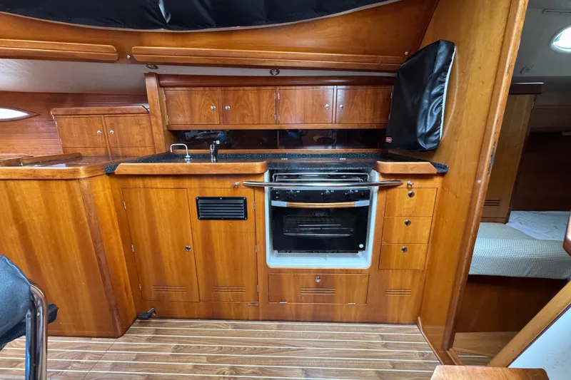 Slide: The Image of Wooden interior of 2004 Alliaura FEELING 44 DI yacht, featuring a compact kitchen area. - 52