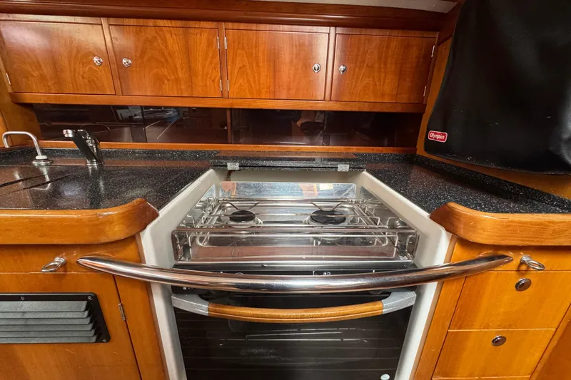 Slide: The Image of 2004 Alliaura FEELING 44 DI yacht kitchen with stove and wooden cabinetry. - 53
