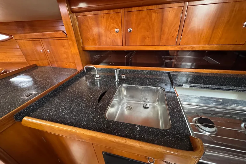 Slide: The Image of Luxurious 2004 Alliaura FEELING 44 DI yacht kitchen with sleek wood cabinetry and modern sink. - 55