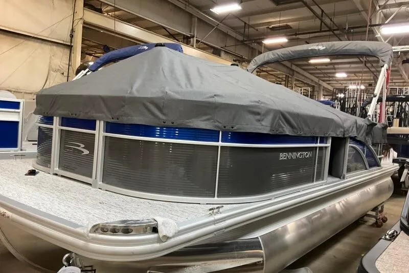 Slide: The Image of 2026 Bennington 22SXSR pontoon boat with cover in a warehouse setting. - 12