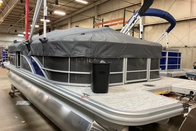 Slide: The Image of 2026 Bennington 22SXSR pontoon boat with cover in a warehouse setting. - 13