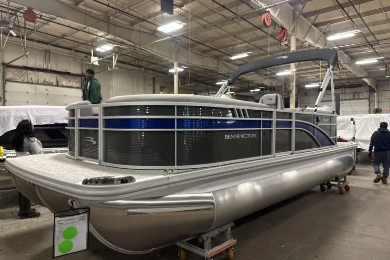 Slide: The Image of 2026 Bennington 22SXSR pontoon boat in a warehouse setting. - 2