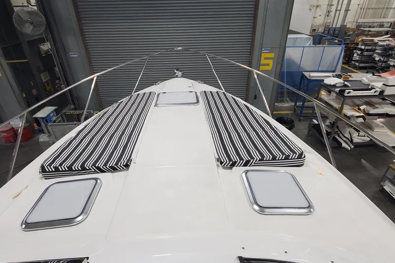 Slide: The Image of 2010 Formula 31 Performance Cruiser with striped cushions on deck in a workshop. - 26