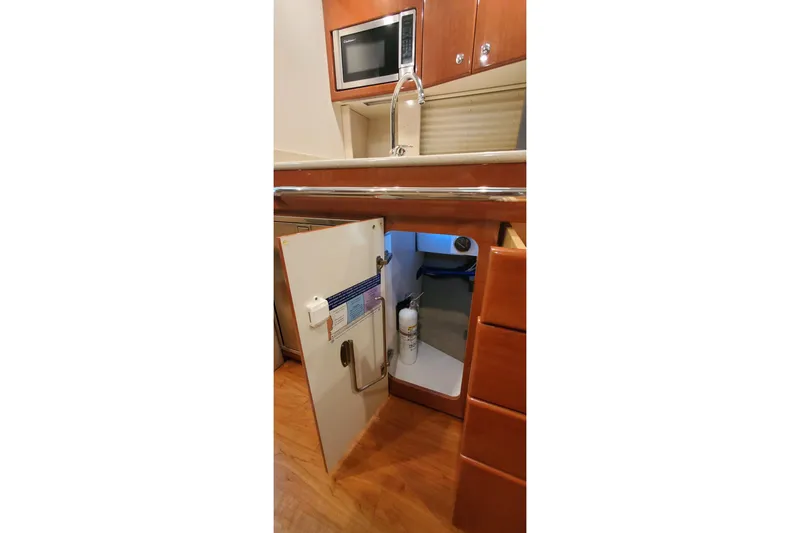 Slide: The Image of 2010 Formula 31 Performance Cruiser kitchen with open cabinet, microwave, and fire extinguisher. - 62