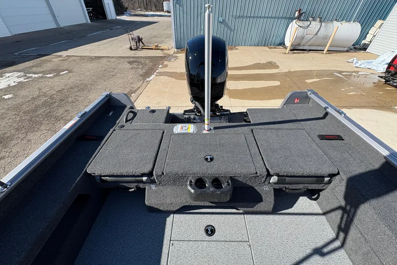 Slide: The Image of 2026 Lund 1875 Impact XS Sport boat interior with motor, docked outdoors. - 28