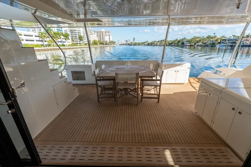Slide: The Image of Luxurious Granocean 57 yacht deck with dining area, overlooking serene waterfront views. - 48