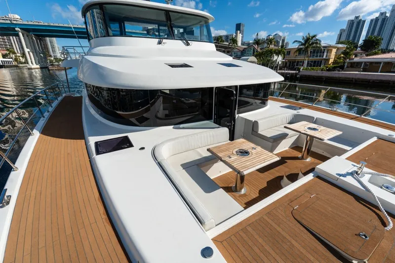 Slide: The Image of Luxurious 2023 Granocean 57 yacht with spacious deck and seating area, docked in a scenic marina. - 54