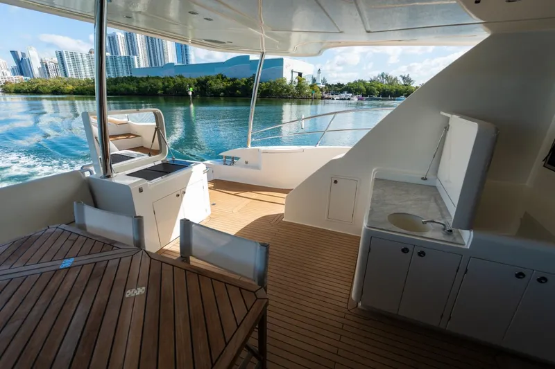 Slide: The Image of Luxurious Granocean 57 yacht deck with city skyline, featuring outdoor kitchen and seating, 2023 model. - 58