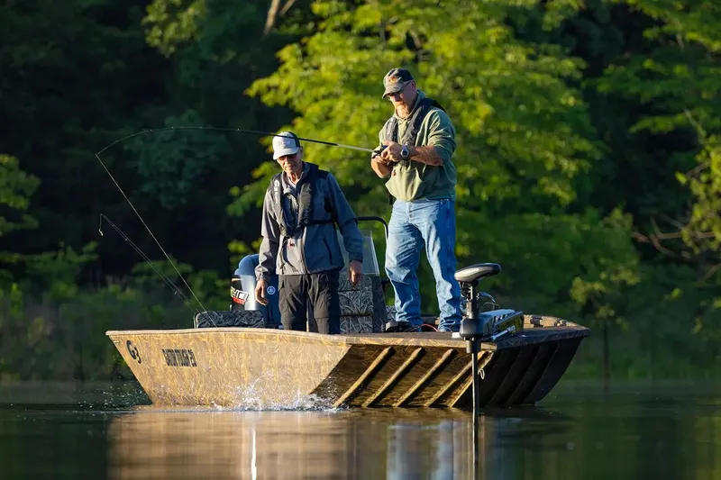 The Image of Two people fishing on a 2026 G3 Gator Tough 20 CC boat in a serene lake. - 0
