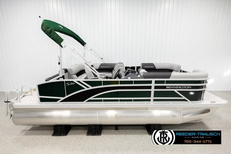 The Image of 2026 Bennington SLJSF pontoon boat with green canopy and sleek design in showroom. - 1