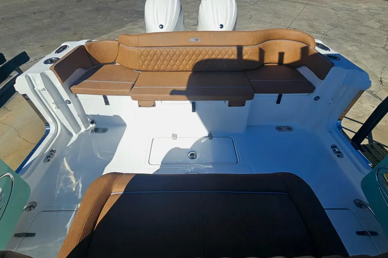 Slide: The Image of 2026 Sea Hunt Ultra 275 Coffin Box boat interior with brown seating and white deck. - 11