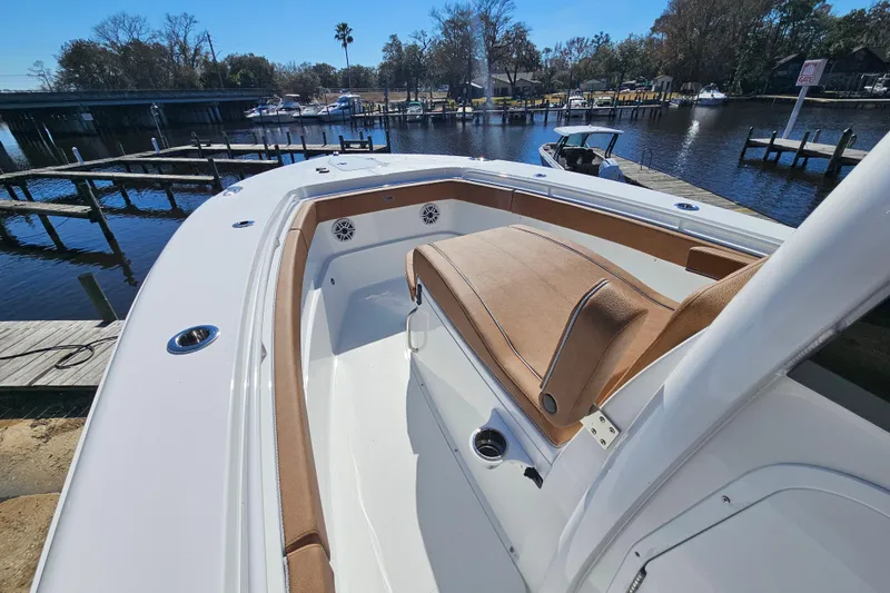 Slide: The Image of 2026 Sea Hunt Ultra 275 Coffin Box boat docked by a serene waterfront. - 24