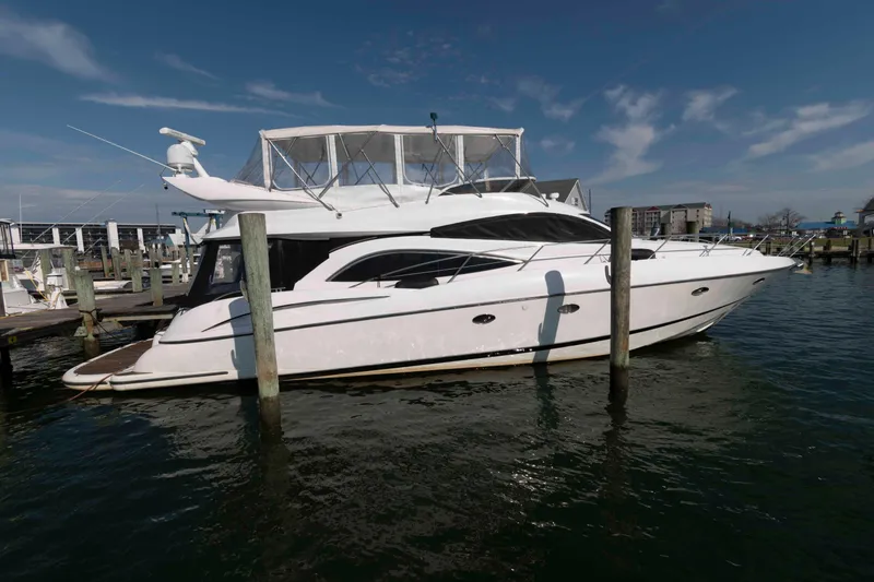 The Image of 2003 Sunseeker Manhattan 56 yacht docked at marina under clear sky. - 0